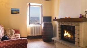 a living room with a fireplace and a window at Casa Bandino in Campiglia dʼOrcia