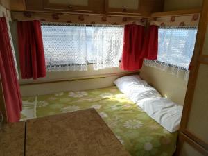 a small room with a bed in front of a window at Caravan near the sea in Ugljan