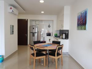 a kitchen with a table and chairs and a refrigerator at Eclipse Residence Pangea in Cyberjaya