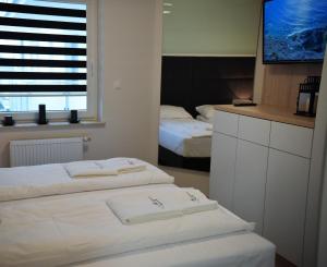a hotel room with two beds and a window at Apartamenty Platan Opieszyn 2 in Września