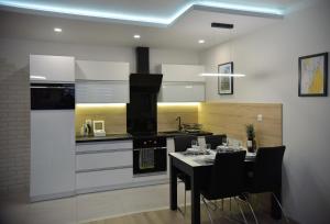 a kitchen with a table with chairs and a stove at Apartamenty Platan Opieszyn 2 in Września +35 photos