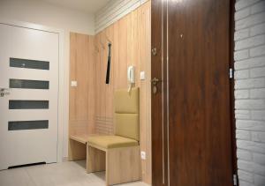 a room with a chair next to a door at Apartamenty Platan Opieszyn 2 in Września