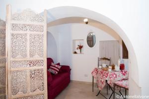 a living room with a red couch and a table at Giardino Segreto in Putignano