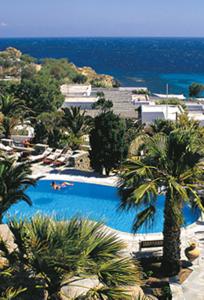 a swimming pool with palm trees and the ocean at Zephyros in Paraga