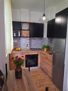 uma cozinha com uma mesa de madeira e um frigorífico em SoLeo em Dubrovnik