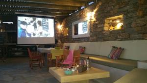 a room with a screen and a table and chairs at Sea & Stone Villas in Koundouros