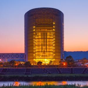 a large building with a reflection in the water at Hotel Kyocera in Kirishima