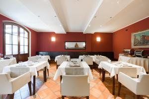 a restaurant with white tables and white chairs at Country Hotel Castelbarco in Vaprio dʼAdda