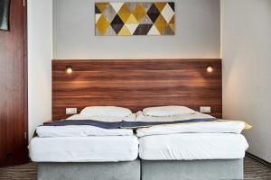 two beds in a room with a wooden headboard at Szekla in Grzybowo