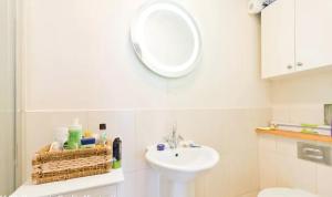a white bathroom with a sink and a mirror at Dublin Corporate Apartment in Lucan