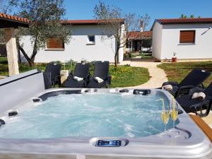 a hot tub in a yard with chairs at Holiday Home Kerniat in Šišan