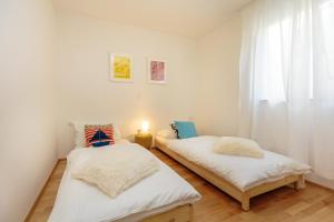 deux lits dans une chambre avec fenêtre dans l'établissement Two bedroom Sunny Suite, à Dubrovnik