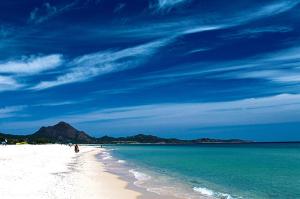 - une plage avec une personne se promenant sur le sable et l'océan dans l'établissement Villetta Valeria, à Costa Rei