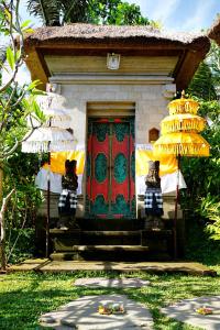 a small house with a red door and yellow chandaliers at deLodtunduh Villa in Ubud