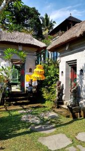 a house with two statues in a yard at deLodtunduh Villa in Ubud