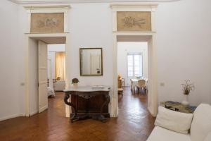 uma sala de estar com uma mesa e um sofá em Residenze al Castello em Cagliari