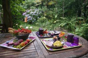 two plates of food on a wooden table with fruit at Un Matin D’été in Lacanau-Océan