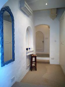 a bathroom with a mirror and a stool in a room at St. Agatha's Bastion in Mdina