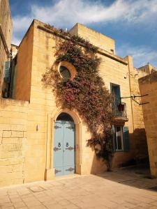 ein Gebäude mit einer Tür mit Blumen darauf in der Unterkunft St. Agatha's Bastion in Mdina