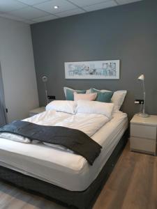 a bedroom with a large white bed with blue walls at Post-Plaza Guesthouse in Húsavík