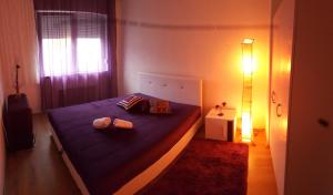een slaapkamer met een blauw bed met 2 kussens bij Pavlovic apartman in Belgrado