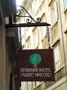 a sign hanging from the side of a building at Boutique Hotel Albero Nascosto in Trieste