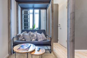 ein Wohnzimmer mit einem blauen Sofa und 2 Tischen in der Unterkunft Meedo I in Berlin
