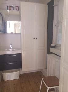 a white bathroom with a sink and a mirror at Beach Holiday Appartements in Dirkshorn