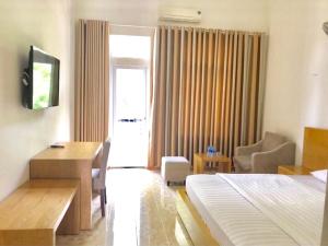 a hotel room with a bed and a desk and chairs at Nhà Khách T284 in Buon Ma Thuot