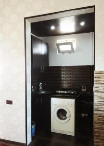 a kitchen with a washing machine in a room at Eka Guest House in Batumi