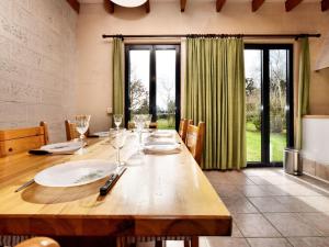 a dining room with a wooden table with wine glasses at Holiday home in peaceful setting and large garden in Rendeux