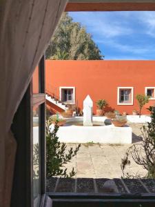 vistas a un edificio con una pared de color naranja en Cortijo El Pozuelo, en Tarifa