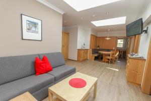 a living room with a gray couch and a red pillow at Landhotel Oberdanner in Saalbach Hinterglemm