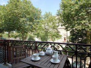 a wooden table with a tea set on a balcony at Mithouard Apartments in Paris