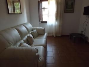 a living room with a couch and a window at Appartamento Il Girasole in Pomonte