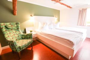 - une chambre avec un lit blanc et une chaise dans l'établissement Hotel Bützower Hof, à Bützow