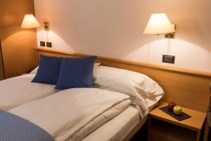 um quarto de hotel com duas camas e uma maçã sobre uma mesa em La Ruota em Morbegno
