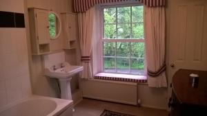 een badkamer met een wastafel en een raam bij Wydemeet in Two Bridges