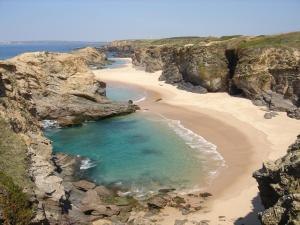 uma vista aérea de uma praia com rochas e água em Parque Campismo Porto Côvo em Porto Covo