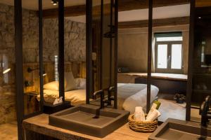 uma casa de banho com um lavatório e um quarto com uma cama em Hotel Victoria - Maison Caerdinael em Durbuy
