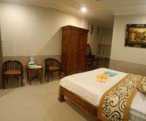 - une chambre avec un lit, une table et des chaises dans l'établissement Murdhasari, à Ubud