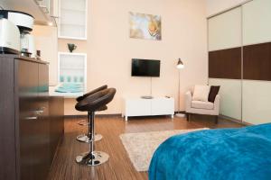 a bedroom with a bed and a chair and a television at Viktoria Central Apartment in Budapest
