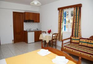 a living room with a table and a kitchen at Panorama in Amorgos