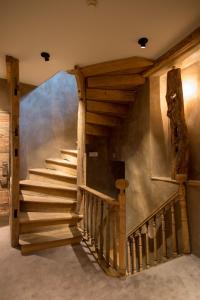 a wooden staircase in a house with a wall at Hotel Victoria - Maison Caerdinael in Durbuy