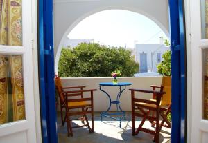 a patio with a table and chairs and a window at Panorama in Amorgos