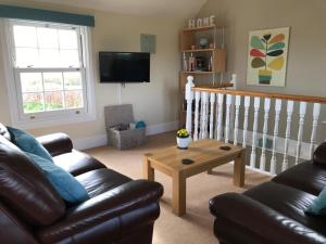 a living room with a couch and a coffee table at Crannaford Cottage in Broad Clyst