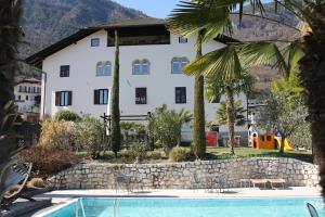 a hotel with a swimming pool in front of a building at Garni Brunnenhof in Caldaro