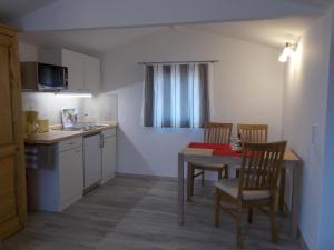 a kitchen with a table and two chairs and a table and a kitchen with at Ferienhaus am Langen See II in Heidesee