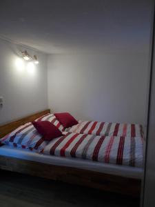 Cette chambre comprend un lit avec des draps rayés rouges et blancs. dans l'établissement Ferienhaus am Langen See II, à Heidesee