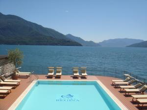 a swimming pool on a deck next to a body of water at Hotel Regina in Gravedona